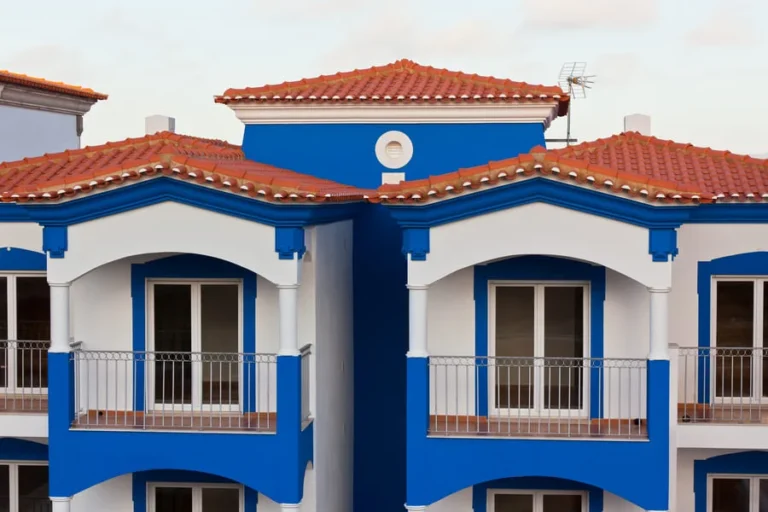 Mediterranean-style blue and white house with red roof tiles.