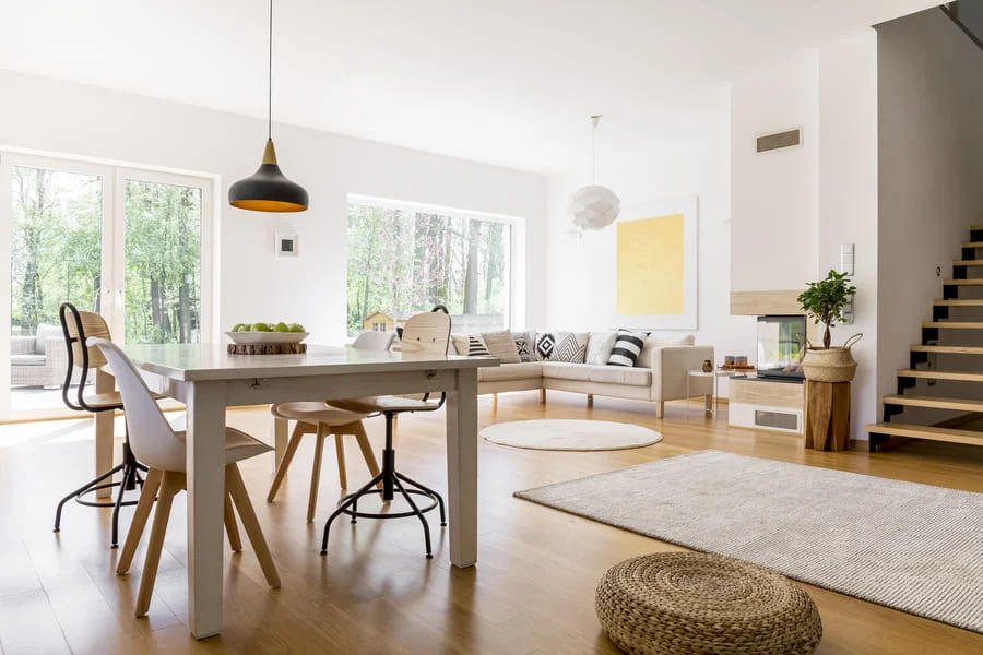 Modern dining room with wooden table and chairs, bright interior.